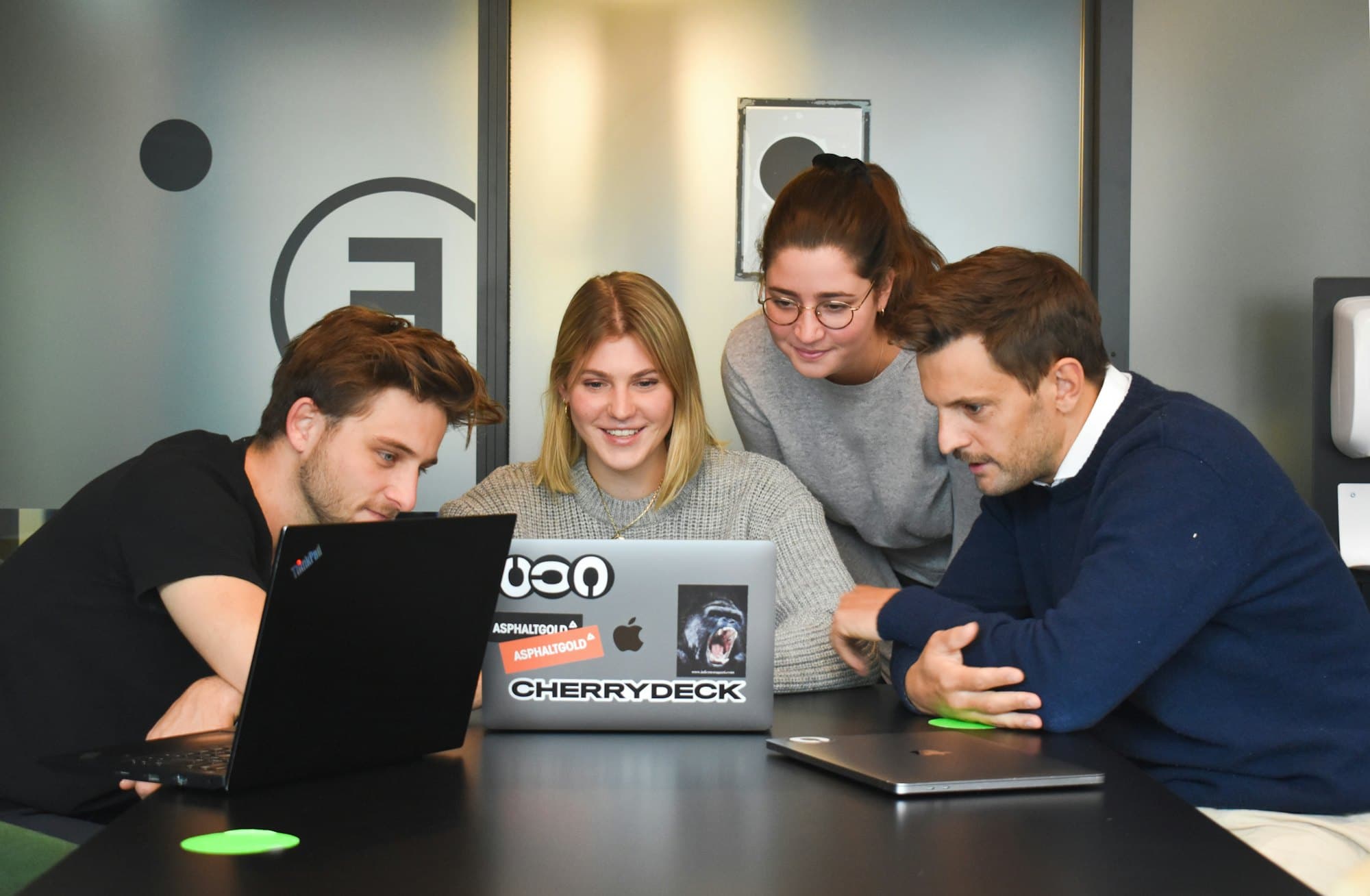 Personas reunidas alrededor de una laptop
